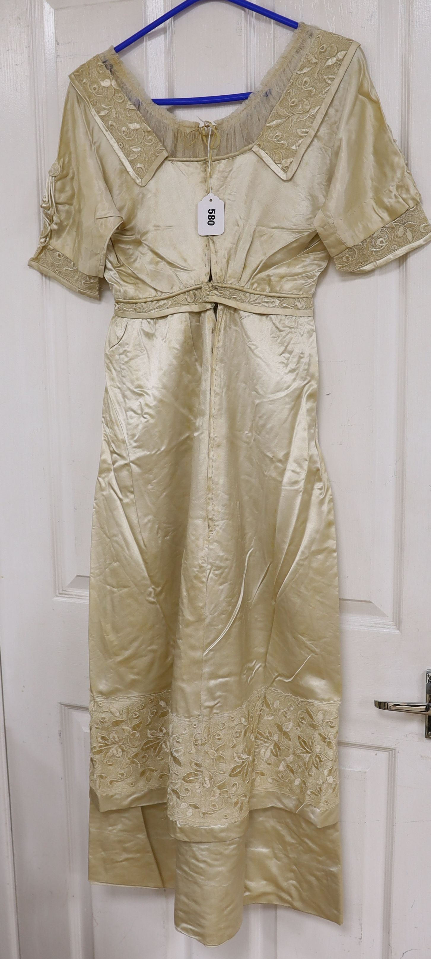 An Edwardian cream satin lady's dress with embroidered panels to base,sleeves front and collar